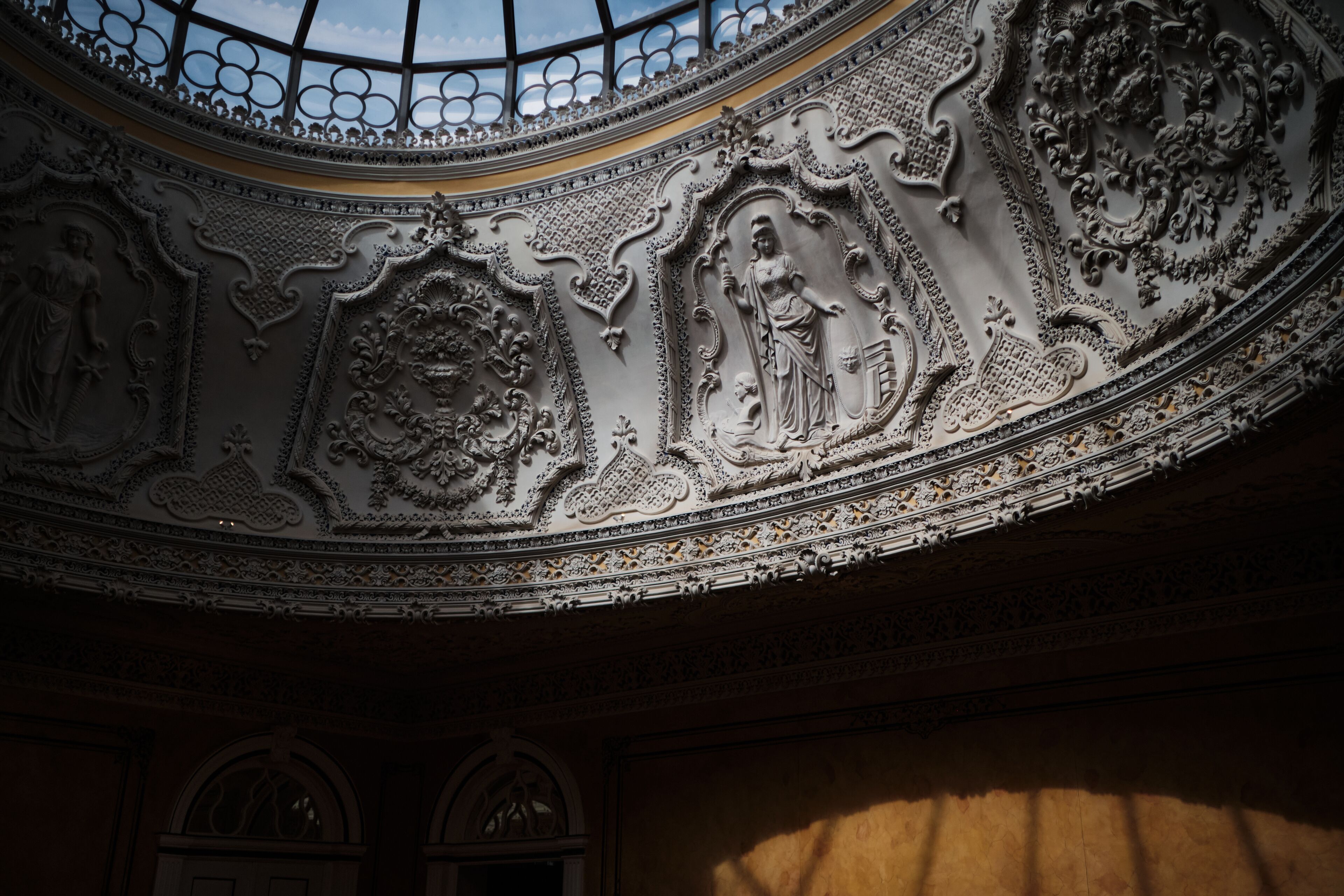 An ornate ceiling with intricate carvings and a skylight.