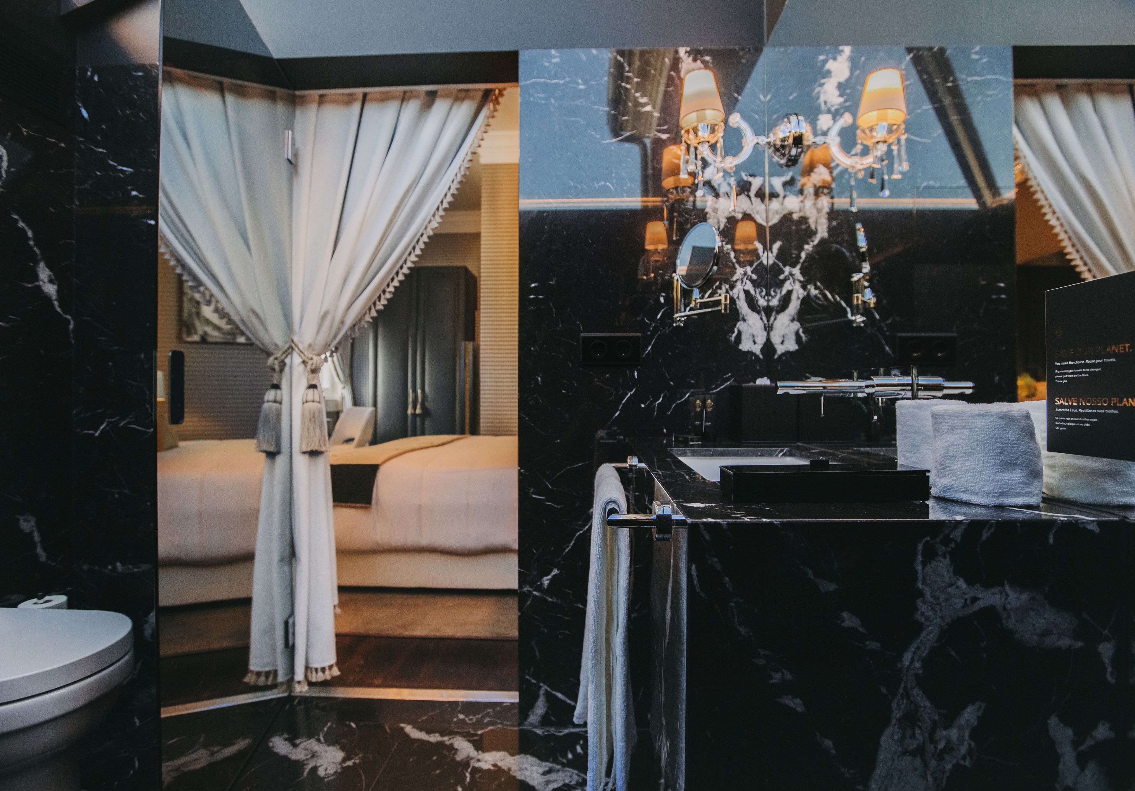 A modern bathroom with a black marble countertop, a sink, and a mirror.
