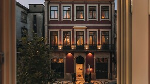 A multi-story building with a balcony, arched windows, and a door with a small step leading to the entrance. - Torel Palace Porto (Porto)