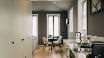 Une cuisine moderne avec un coin repas, un plancher en bois et une vue sur le salon.