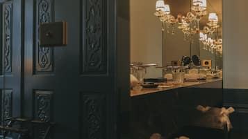 Une salle de bain avec un miroir, un lustre et un porte-serviettes.