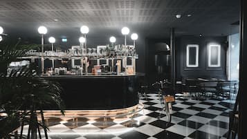 Un coin bar avec un sol à carreaux, un comptoir orné de bouteilles et une enseigne sur laquelle on peut lire « BONDU PARIS ».