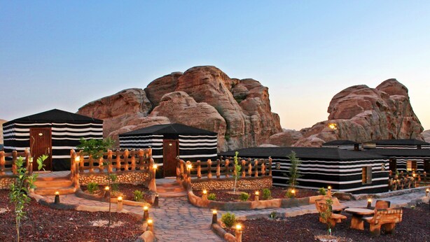 Yurts with striped awnings, a stone pathway, and seating areas with candles. - Seven Wonders Luxury Camp (Wadi Musa)