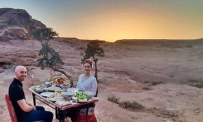 Eine Wüstenlandschaft, ein Tisch ist für eine Mahlzeit gedeckt.
