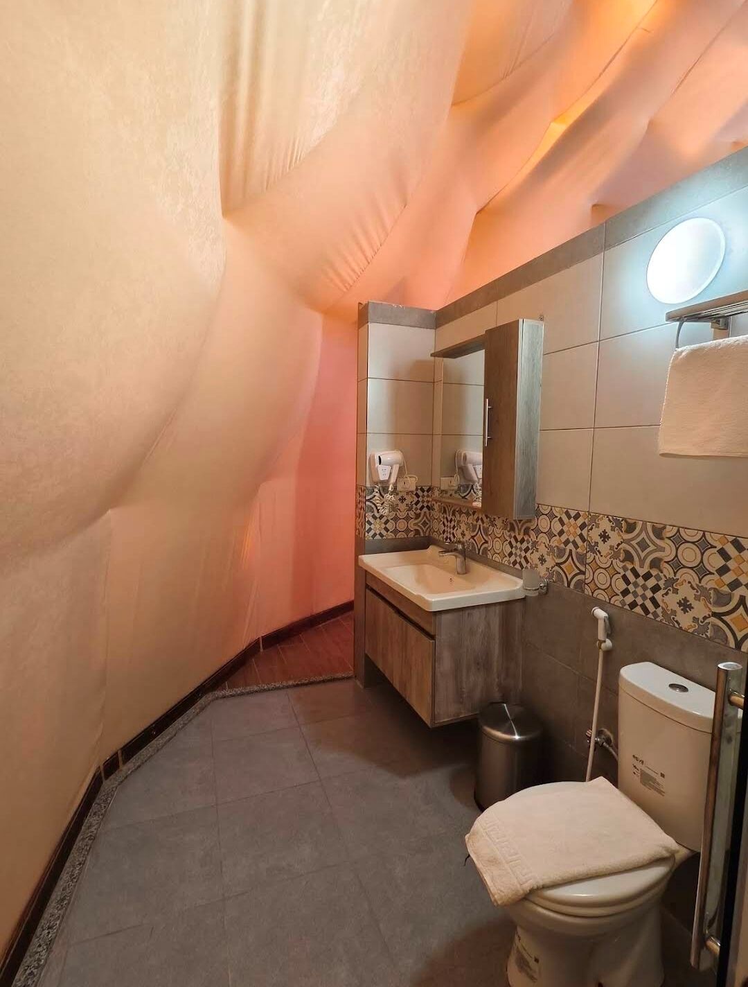 Een kleine badkamer met wastafel, spiegel en toilet.