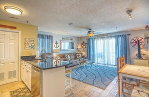 A compact living space with a kitchenette, a dining area, and a seating area with a view of the outdoors. - Oceanview Paradise: Relaxing 2-Bedroom Condo in Surfside Beach (Surfside Beach)