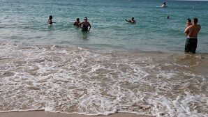 A beach with people swimming and standing in the water. - Mare 1660 (Carolina)