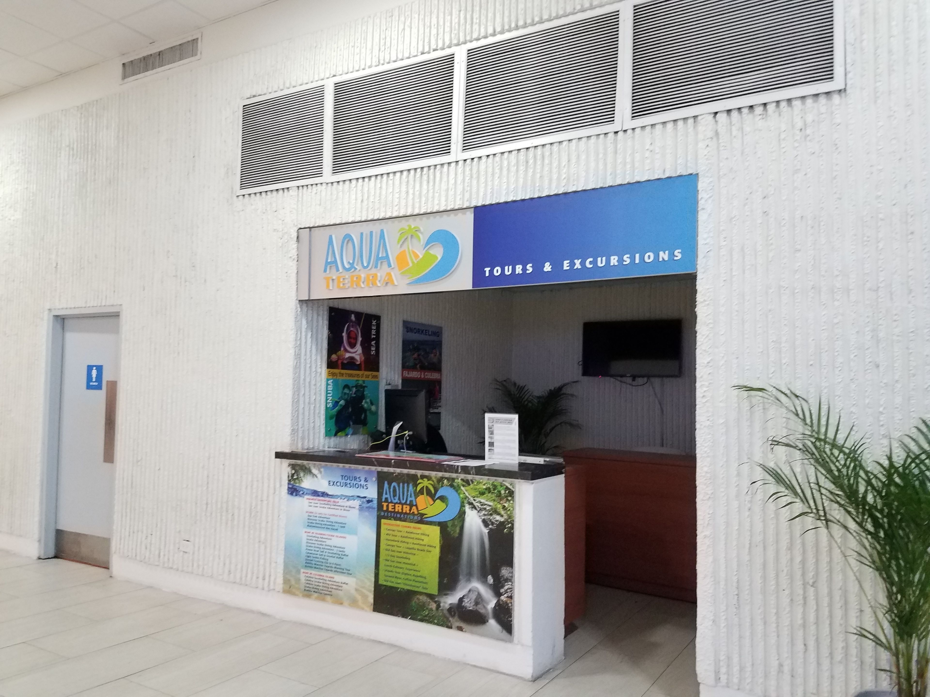 Una recepción con un letrero que dice 'AQUA TERRA TOURS & EXCURSIONS'.