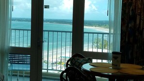 A balcony with a view of the ocean and beach, a table with a mug, and a bench. - Mare 1660 (Carolina)