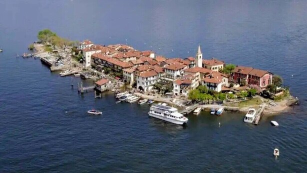 An aerial view of a coastal town with buildings, a church, and boats. - Casa Marina .. a stone's throw from the center! (Verbania)