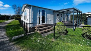 A mobile home with a covered porch and a fenced yard. - RBR 264 - Beach Resort Kamperland (Kamperland)