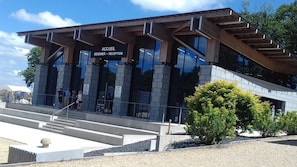 A modern building with a reception area, large windows, and a staircase leading up to the entrance.