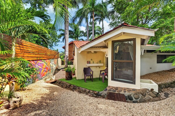 A house with a small patio, a dining area, and a view of the surrounding greenery. - The Beach Bungalows Tamarindo B&B (Tamarindo)