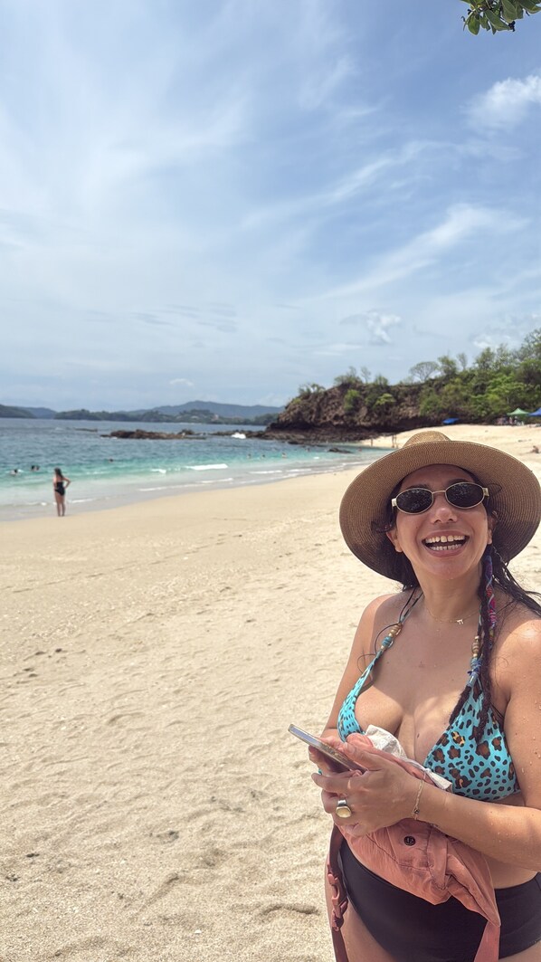 A person on a sandy beach with a clear sky and calm sea in the background. - The Beach Bungalows Tamarindo B&B (Tamarindo)