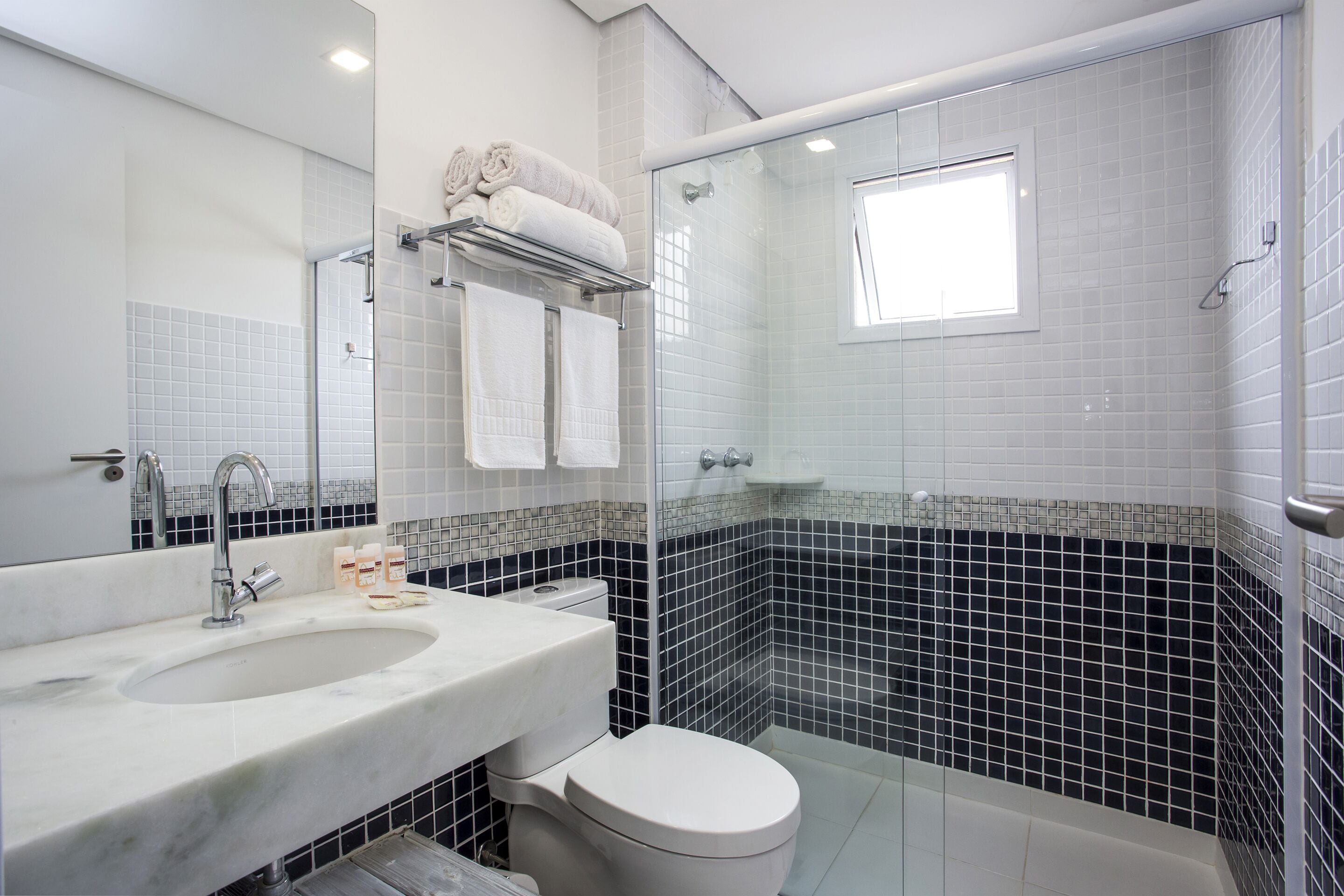 A bathroom with a white sink, a toilet, and a glass-enclosed shower.