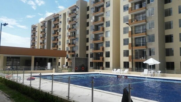 A modern apartment building with a swimming pool, outdoor seating, and a covered area. - Lindo Apartamento (Ricaurte)