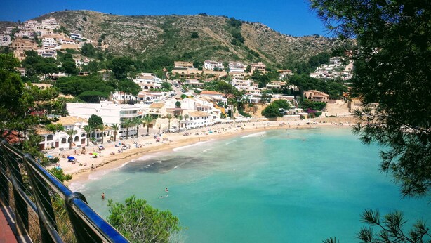 A coastal town with a beach, houses, and a mountain backdrop. - Spectacular Frontline Apt Sea Views 2mins Walk to Beach /5mins to Moraira (Moraira)