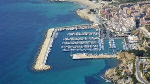 An aerial view of a coastal marina with numerous boats docked, surrounded by residential buildings and a beach. - Spectacular Frontline Apt Sea Views 2mins Walk to Beach /5mins to Moraira (Moraira)