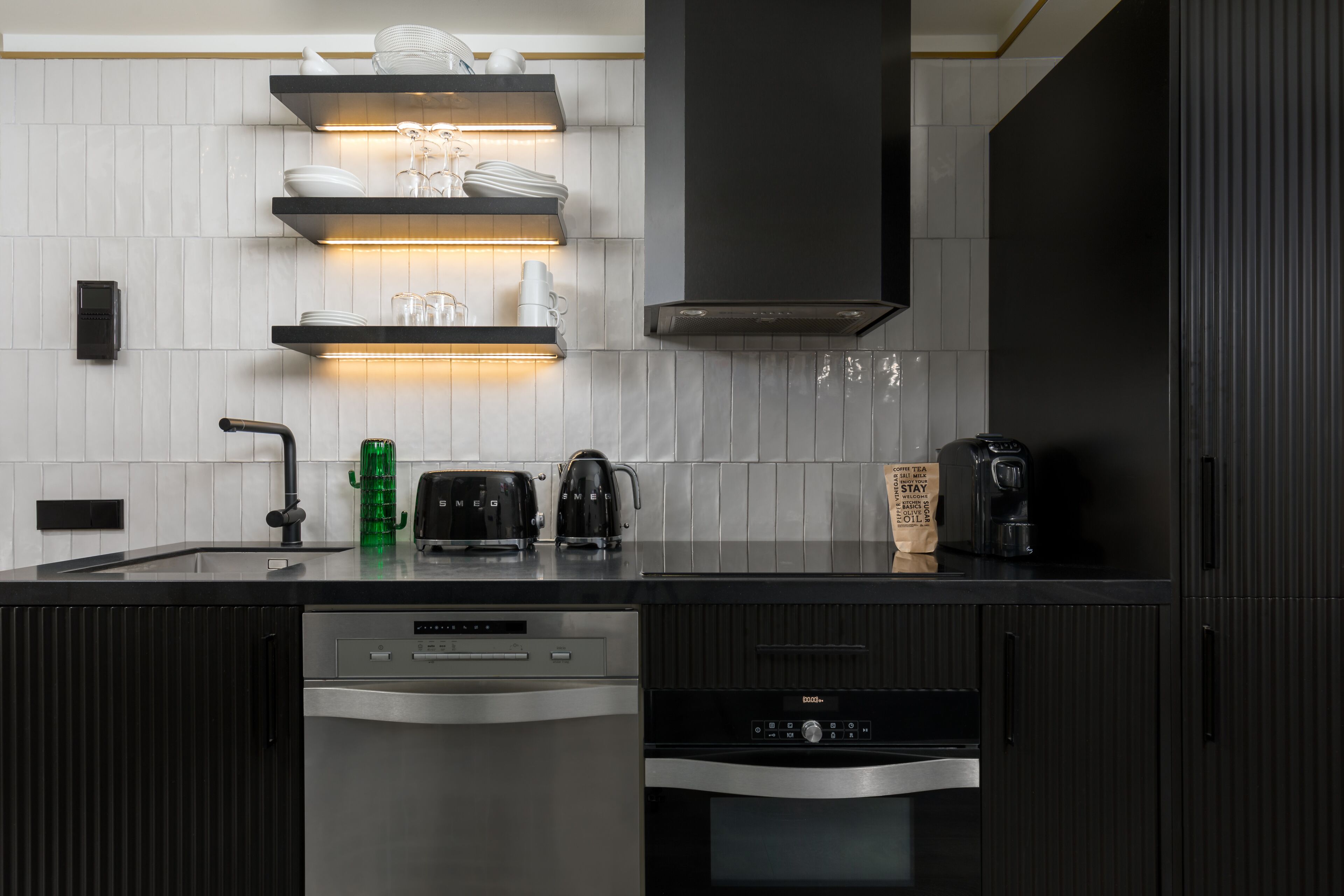 A modern kitchen with built-in appliances, a dishwasher, and a coffee maker.