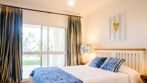 Un dormitorio con una cama grande, vistas a través de una puerta corrediza y una decoración con forma de corazón en la pared.