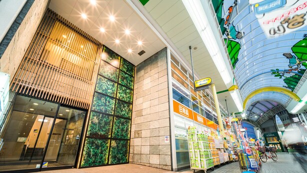 A modern shopping mall interior with a visible hotel entrance, a variety of retail stores, and a bicycle parked near the entrance. - Super Hotel Takamatsu Tamachi (Takamatsu)