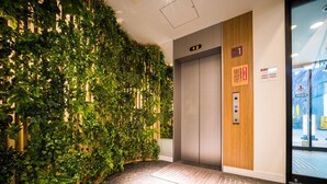 An elevator with a wooden panel and a sign indicating the first floor. - Super Hotel Takamatsu Tamachi (Takamatsu)