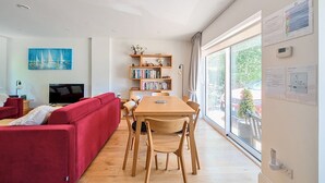 A modern living room with a red sofa, wooden dining table, and bookshelves. - ★ Luxury Oxford Apartment ★ Sleeps 4, Free Parking - Pass the Keys (Oxford)