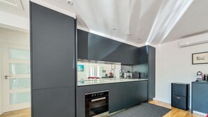 A modern kitchen with dark cabinetry, a built-in oven, and a large window. - ★ Luxury Oxford Apartment ★ Sleeps 4, Free Parking - Pass the Keys (Oxford)