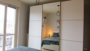 A bedroom with a bed, a window, and a wardrobe. - VINHOME -Your WINEderful stay in Alba. Apartment in the center of Alba (Alba)