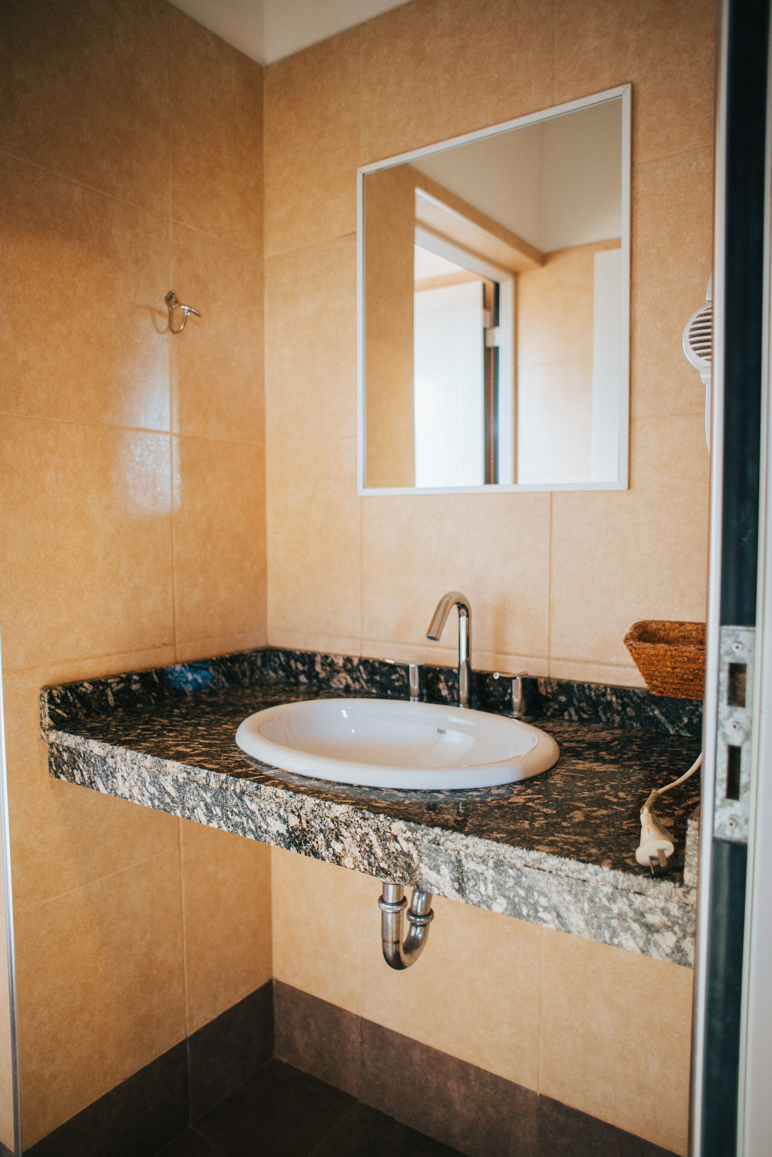 Un bany amb un lavabo, mirall i barra de tovalloles.