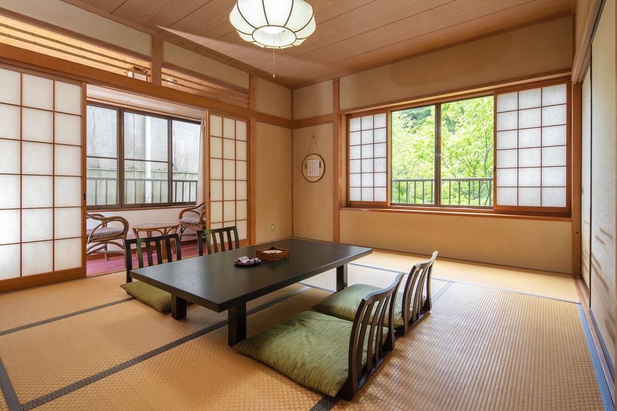 A traditional Japanese room with tatami flooring, a low table, and sliding doors.