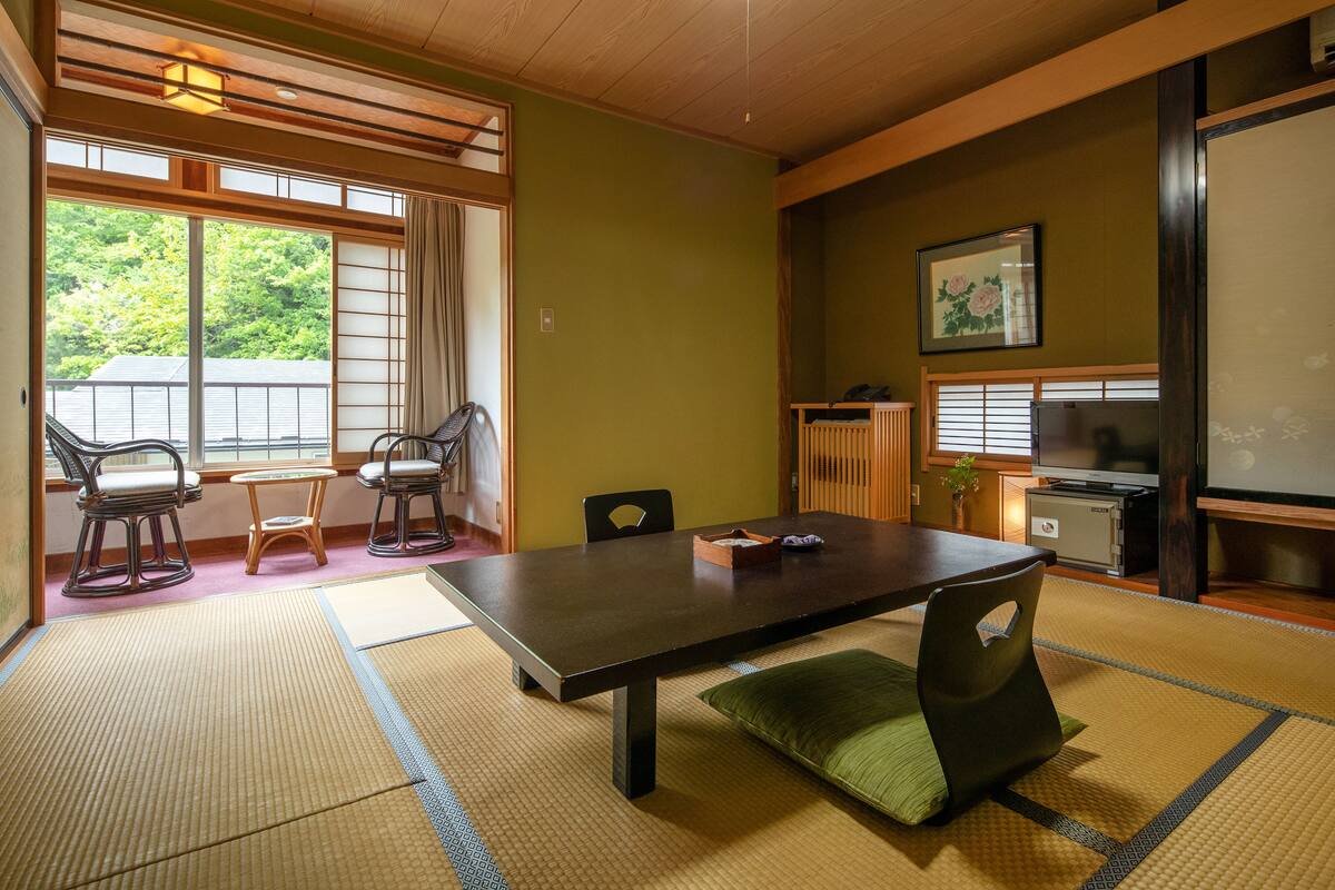 A traditional Japanese room with tatami flooring, a low table, and shoji screens.