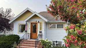 A single-story house with a front porch, a wooden door, and a small front yard. - Prairie Cottages in historic Rapid City (Rapid City)