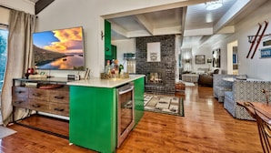 A modern living space with a kitchen island, a fireplace, and a dining area. - New! Majestic Mountain Retreat (Incline Village)