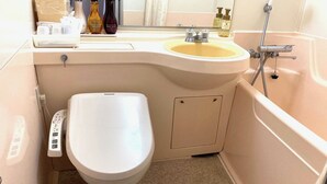 Een badkamer met toilet, wastafel en douche.