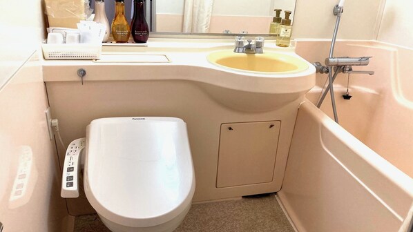 A bathroom with a toilet, sink, and shower. - Royal Hotel Miyakonojo (Miyakonojo)