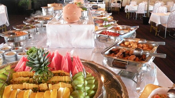 Een buffetopstelling met diverse gerechten en een centraal broodpresentatie.