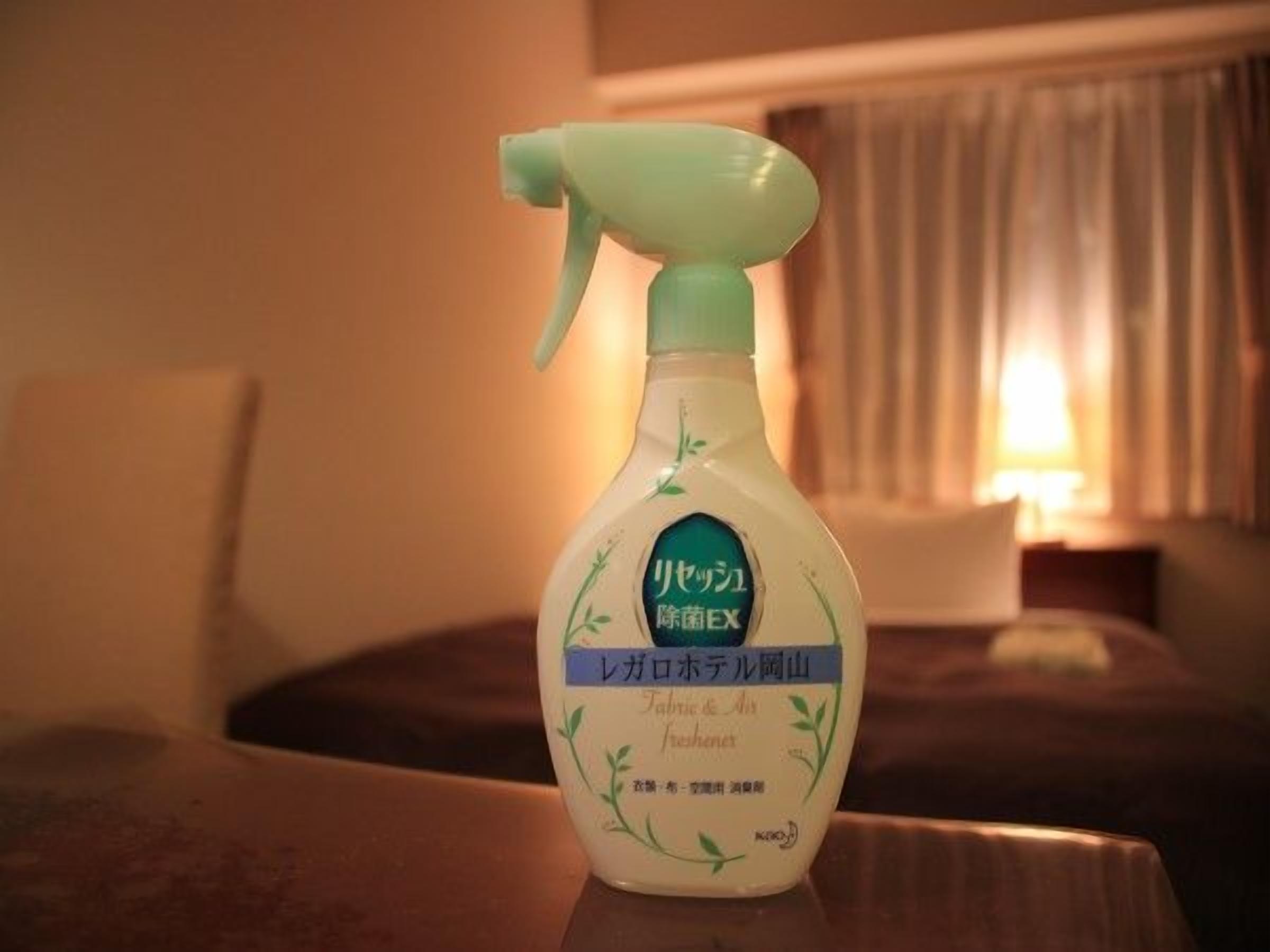 Una botella de producto de limpieza sobre una mesa en una habitación de hotel.