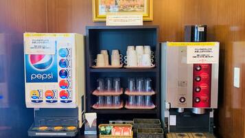 A vending machine area with a Pepsi dispenser, a coffee machine, and a shelf with cups.