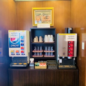A vending machine area with a Pepsi dispenser, a coffee machine, and a shelf with cups. - Regalo Hotel Okayama (Okayama)