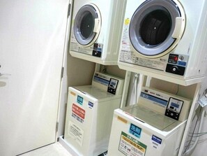 A laundry facility with multiple washing machines and dryers. - Regalo Hotel Okayama (Okayama)