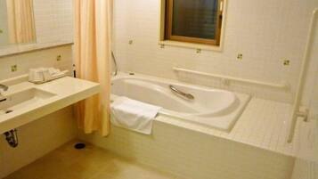 A bathroom with a bathtub, a sink, and a window.