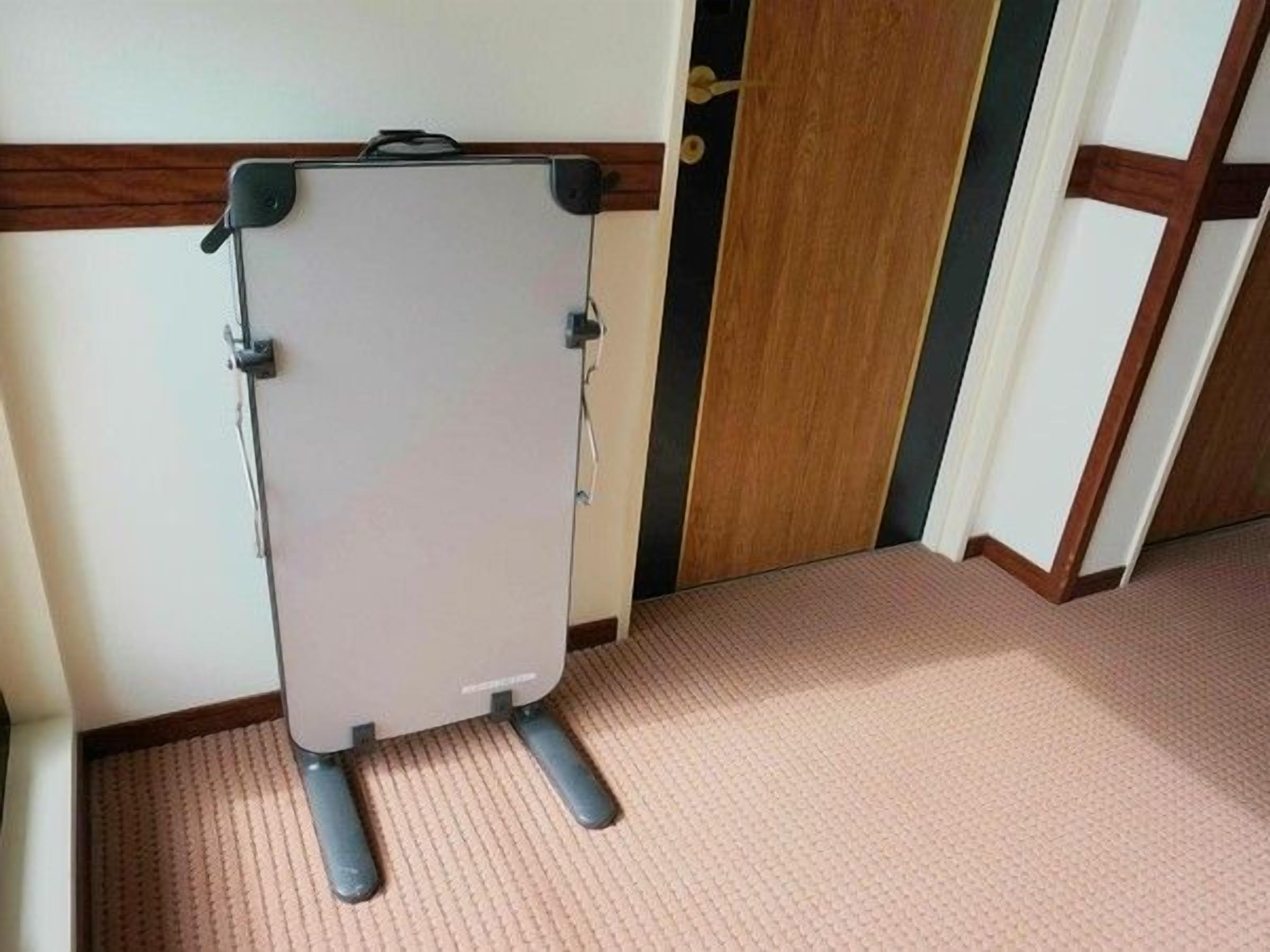 Una pizarra montada en la pared, con una puerta de madera y suelo alfombrado.