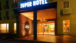 The exterior of the Super Hotel with a prominent illuminated sign, a welcoming entrance, and a visible reception area. - Super Hotel Kadoma (Kadoma)