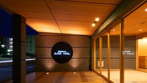A hotel entrance with a neon sign reading "Welcome to SUPER HOTEL" and a glass door with a sign "Super Hotel". - Super Hotel Kadoma (Kadoma)