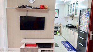 A modern kitchen with a built-in TV, a microwave, and a refrigerator. - WELCOME TO MOONLIGHT OSC (Tp. Vũng Tàu)