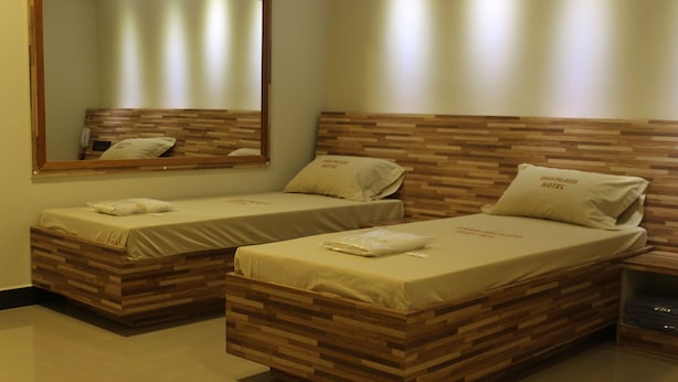 Two single beds with wooden headboards and a large mirror above them. - Gran Palazzo Hotel (São Paulo)