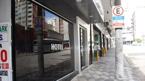 A hotel with a large window displaying the word "HOTEL" and a sign indicating a 12.00 price for a room. - Gran Palazzo Hotel (São Paulo)