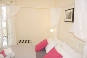 Une chambre à coucher avec un lit, des oreillers, une table de chevet, une lampe et un tableau au mur.