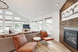 Relax in this stylish living room with a large sofa, flat-screen TV, and cozy fireplace.